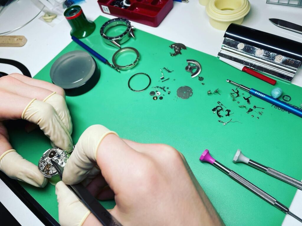 Revision eines zerlegten Uhrwerks in der Werkstatt